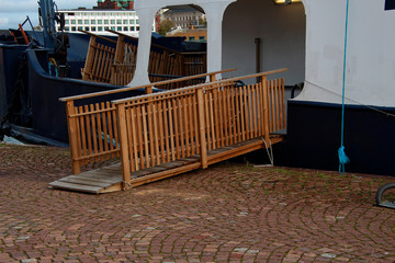 wooden gangway with railing mounted on the pier for boarding the ship