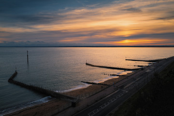Sunset at the artificial beach of the western undercliff in Ramsgate, Kent, UK which has groins as water breakers.