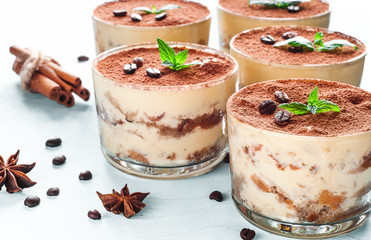 Tiramisu in the glass decorated whith mint on the wooden background