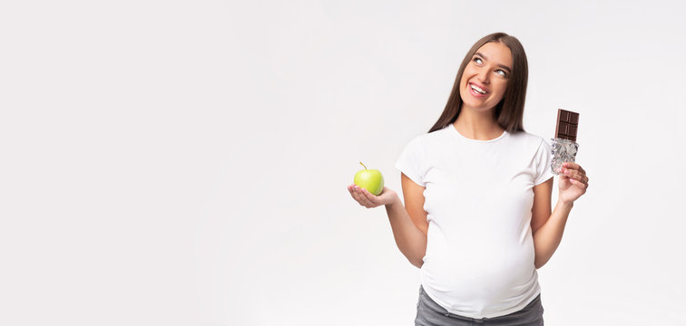 Pregnant Lady Holding Apple And Chocolate Over Gray Background, Panorama