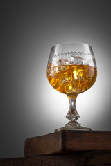 Orange drink with ice in winglass on the wooden table
