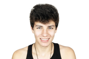 Handsome teenage boy smiling sincerely on a white background, isolated. The guy has beautiful white teeth because he has had braces for a long time. Dental concept