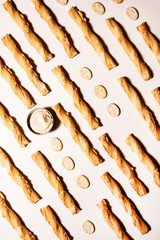 Salted twisted crackers in a line with hummus sauce. Abstract food conception.