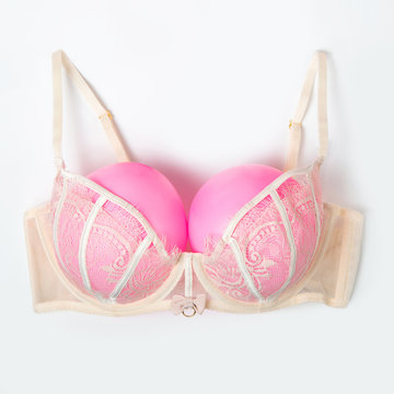 Bra with pink balloons on a gray background. Fun, conceptual photo, great big breasts.