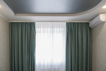 Apartment view with white suspended drywall ceiling with grey stretch ceiling and conditioner in apartment