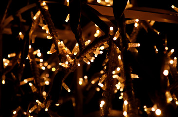 Part of Christmas decorative yellow, golden, white flashing lights, close up. Detail of New Year and Christmas decorations, string rice lights bulbs. Ornaments to christmas celebration, holiday scene. - Powered by Adobe