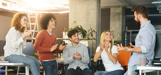 Group of colleagues applauding to new member of company