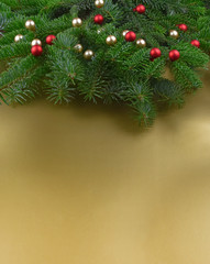 Christmas decorations balls on tree branch stock images. Christmas tree branch on a golden background. Beautiful natural Christmas background. Xmas decorations on a gold background