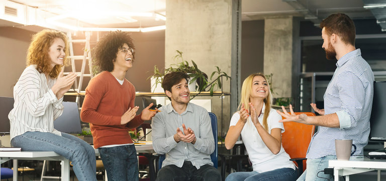 Group of colleagues applauding to new member of company