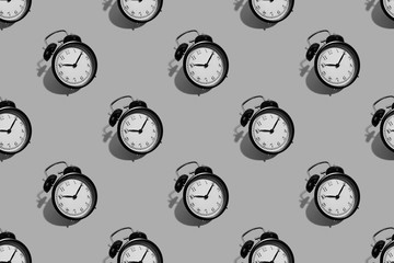 Many black classic style alarm clock with hard shadow isolated on background. Black and white smile time concept. Pattern