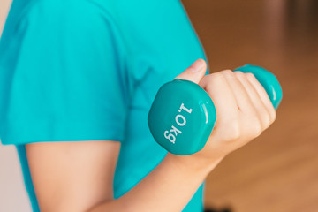 Stock photo of a young woman holding a dumbbell