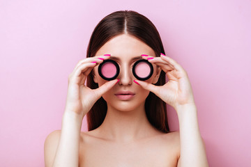 Close up of beautiful young woman's face with clean perfect skin with shadow, blush. Portrait of beauty model with natural nude make up. Pink peach coral background, copyspace.