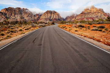 A two lane road running through a desert landscape