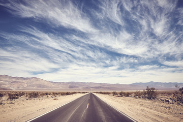Fototapeta na wymiar Desert road in Death Valley, color toning applied, USA.