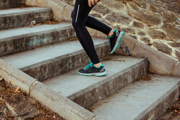 Stock photo of a young woman climbing stairs while running