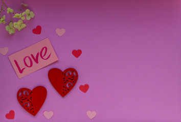 Red and pink hearts on the purple background. Valentin's Day, top view. 