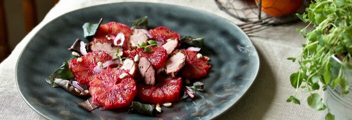 salad with red orange (blood orange), duck breast, beet top (chard), sunflower seeds, red onion. gourmet recipe, winter salad