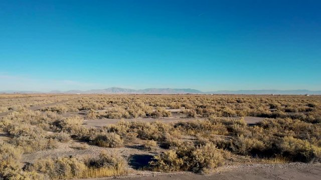 Aerial-Low pass over desert vegetation and rectangular cement pads that are all that remains of the WWII Japanese internment camp Topaz in the Great Basin Desert of Utah.
