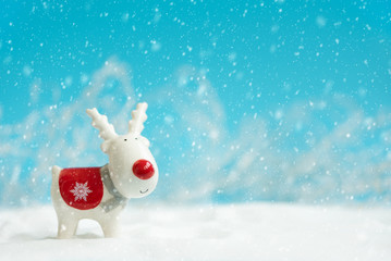 Christmas reindeer toy on snowy background. Christmas or New Year celebration concept. Copy space
