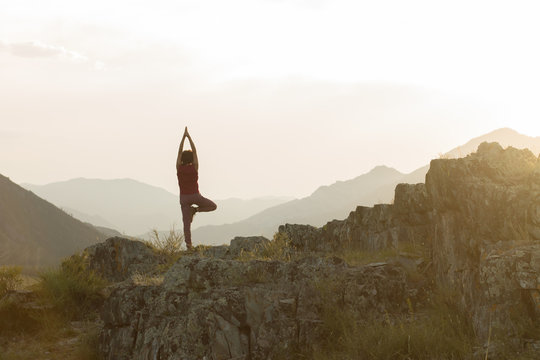 Silhouette Of Woman Doing Yoga On Top Of Mountain