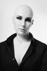 Black and white portrait of skinhead woman with smoky eye makeup