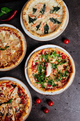 Traditional Italian pizza on a dark background top view copy space.