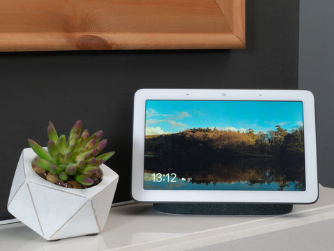 Smart home device screen on mantlepiece with picture on show