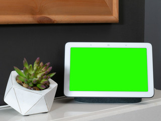 Smart home speaker voice assistant touchscreen in home setting with green screen