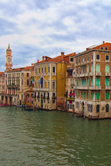 Scenic morning view of medieval colorful buildings near Grand Canal, the major water-traffic corridor in the city. Cloudy autumn morning. Travel and tourism concept. Venice, Italy