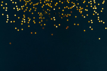 Golden star glitter confetti frame on dark black background. Festive holiday background....