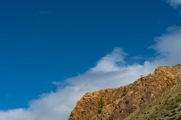 Fototapeta premium Rocks under blue sky. Sunny day in mountain valley. Colorful hills, Hiking in summer