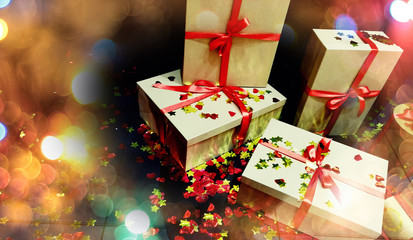 boxes with Christmas gifts tied with red ribbon on a dark background, around the bokeh blurred festive for postcards. the image has noises and artifacts