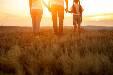 Unrecognizable family enjoying sunset in nature