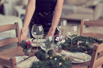 woman is waiting for guests and sets the table. festive laying table, preparation for christmas dinner.