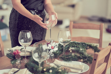 woman is waiting for guests and sets the table. festive laying table, preparation for christmas dinner.