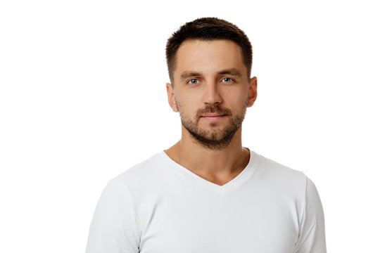 young handsome bearded man in casual white sweater poses in studio on white background