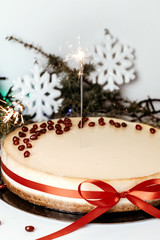 New Year cheesecake with with sparklers, red ribbon.