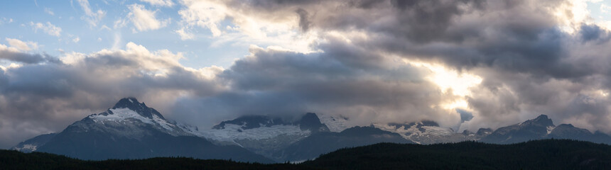 Striking and Dramatic Panoramic Canadian Landscape View of the Mountain Peaks during a cloudy sunset. Taken in Tantalus Lookout near Squamish and Whistler, North of Vancouver, BC, Canada.