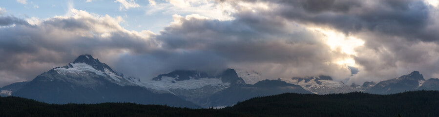 Striking and Dramatic Panoramic Canadian Landscape View of the Mountain Peaks during a cloudy sunset. Taken in Tantalus Lookout near Squamish and Whistler, North of Vancouver, BC, Canada.