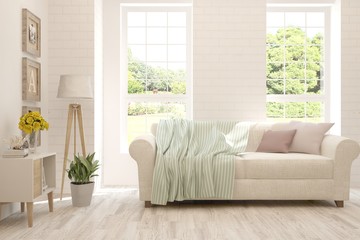Stylish room in white color with sofa and summer landscape in window. Scandinavian interior design. 3D illustration