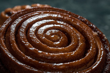 Bun with raisins, cinnamon bun, meat pie on saucer on green marble background