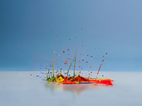 Multi coloured acrylic paint splashing on a surface