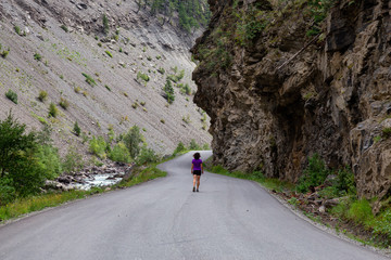 Adventurous Girl walking on a Scenic Road towards Gold Bridge in the Valley surrounded by Canadian Mountain Landscape. Taken near Lillooet, British Columbia, Canada.