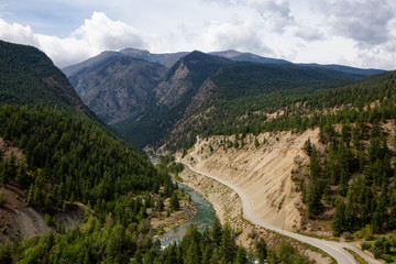 Fototapeta na wymiar Aerial View of a Scenic Dirt Road towards Gold Bridge in the Valley surrounded by Canadian Mountain Landscape. Taken near Lillooet, British Columbia, Canada.