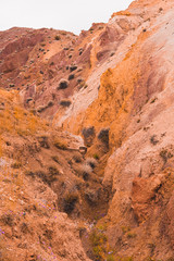 Rocks in canyon of dry river bed. Drought due to climate change. Soil erosion of hills. Red sand in mountains