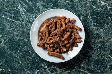 Rye crackers on green marble background view from above