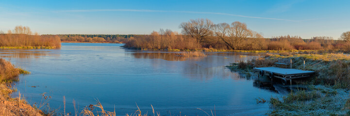 Panoramic view of the river bay covered with the first ice in November