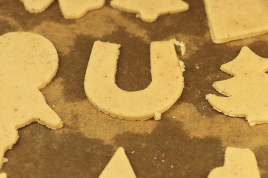 Golden horse shoe made from raw gingerbread pastry. Happy christmas is coming soon. Sweets for Santa Claus or Baby Jesus. Concept of helpness and winter holidays.