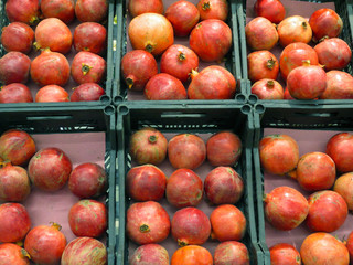Fresh red pomegranate fruit in store containers.