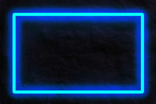 blue neon light on a brick wall at night